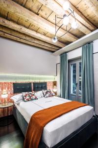 Locanda Pandenus Brera في ميلانو: غرفة نوم بسرير كبير بسقف خشبي