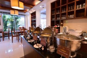 - un buffet dans un restaurant avec 2 grands pots dans l'établissement Rapeepan Ville Hotel, à Ubon Ratchathani