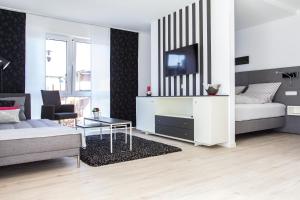 a white living room with a couch and a tv at Refugium 2 in Emsdetten