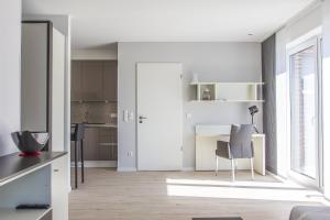 ein weißes Wohnzimmer mit einem Tisch und einem Stuhl in der Unterkunft Refugium 2 in Emsdetten