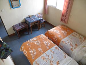 a room with two beds and a table and a chair at Hotel Chalet in Chichicastenango +56 photos