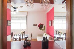 a dining room with pink walls and a table and chairs at Flat Imperador in Petrópolis