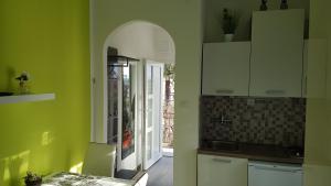 uma cozinha com paredes verdes, uma mesa e uma porta em Apartment Zara em Crikvenica