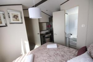 um quarto com uma cama e uma casa de banho com um lavatório em Jackson Lodge em Perth