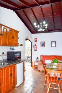 Casa Domingo Simón في فوينكالينتي دي لا بالما: مطبخ وغرفة معيشة مع طاولة وأريكة
