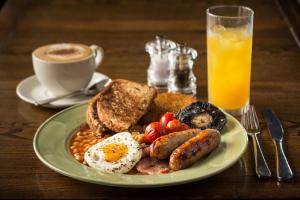 a plate of breakfast food with eggs sausage beans and a cup of coffee at Dovey Inn in Aberdyfi
