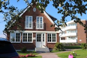 una casa in mattoni rossi con un bianco di Yellow-Upmarine a Westerland