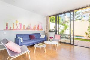 un soggiorno con divano blu e tavolo di L'alzina Apartment a Barcellona