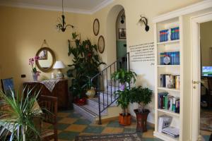 a hallway with plants and a staircase with books at I Tetti di Girgenti in Agrigento
