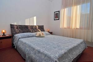 Schlafzimmer mit einem Bett mit blauer Decke in der Unterkunft Apartments Jerina in Sukošan