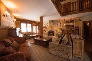 a living room with couches and a stone fireplace at Winston Lodge in Golden