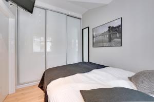 biała sypialnia z łóżkiem i dużymi oknami w obiekcie La Rose - Luxury Neptun Park w Gdańsku