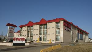 a large building with a sign in front of it at Westwind Motor Inn Hotel in Drayton Valley