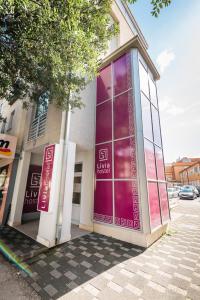 a building with a purple sign on the side of it at Boutique Hostel Livia in Metković