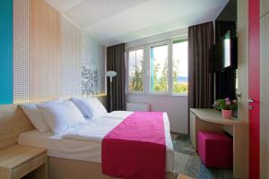 una camera d'albergo con un letto e una finestra di Hotel Cosmopolit a Sarajevo