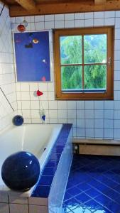 シュラートミンクにあるBio Appartement Pichlerのバスルーム(青いバスタブ、窓付)