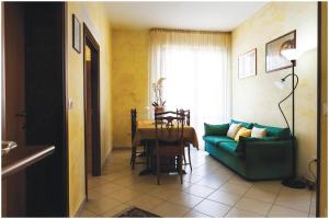 uma sala de estar com um sofá verde e uma mesa em Guest House Il Faro em San Benedetto del Tronto