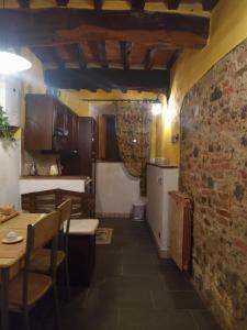 a kitchen and dining room with a table and a brick wall at Appartamento Crete Senesi in Castelnuovo Berardenga