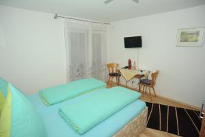 Un dormitorio con una cama con almohadas azules y una mesa. en Gasthaus-Pension Fischerkeller, en Randegg