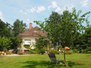 a chair sitting in a yard in front of a house at Cour Tholmer in Touques