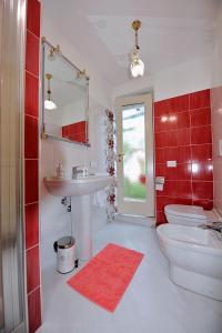 a bathroom with a sink and a toilet and red tiles at A casa di Galdo e VittoriAnna in LʼAquila +13 photos