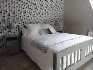 TrélévernにあるLe gîte du forgeronの白い大型ベッドとレンガの壁が備わるベッドルーム1室が備わります。