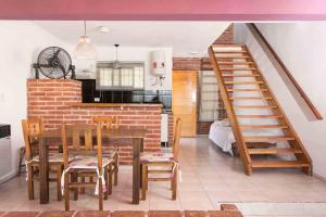 a dining room and kitchen with a staircase and a table and chairs at Complejo Acanto in Villa Carlos Paz