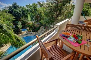 uma varanda com mesa e cadeiras e uma piscina em Riviera Maya Suites em Playa del Carmen