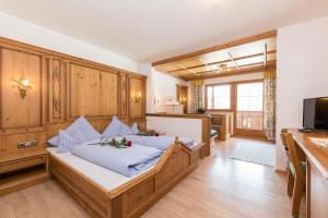 a bedroom with a bed with blue pillows on it at Pension Margretenhof in Fulpmes