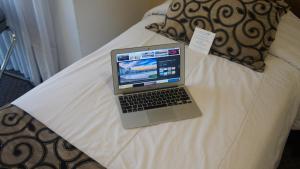 a laptop computer sitting on top of a bed at Palm Beach Plaza Hotel in Montevideo