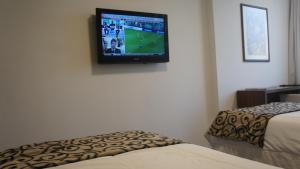 a television hanging on a wall in a room at Palm Beach Plaza Hotel in Montevideo