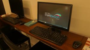 a computer monitor and keyboard sitting on a desk at Palm Beach Plaza Hotel in Montevideo