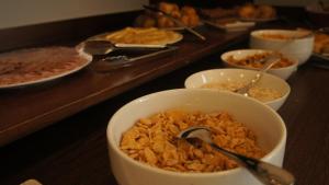 a buffet line with bowls of cereal and other food at Palm Beach Plaza Hotel in Montevideo