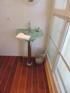 uma casa de banho com um lavatório verde e uma lata de lixo em chambre single avec breakfast em Cannes