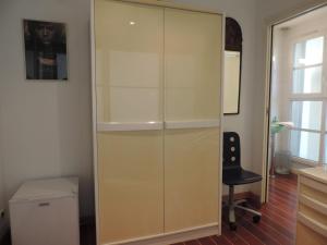 a glass closet with a black chair in a room at chambre single avec breakfast in Cannes