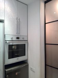a kitchen with a microwave and a refrigerator at Comfort Apartment on Bogoyavlenskiy in Mykolaiv