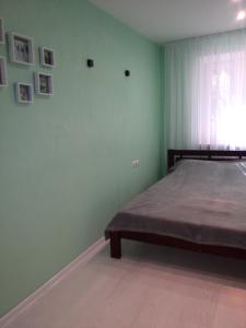 Comfort Apartment on Bogoyavlenskiy في نيكولايف: غرفة نوم بسرير وجدار أخضر