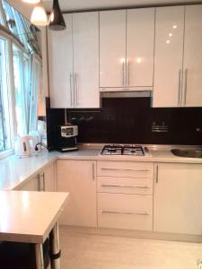 a white kitchen with white cabinets and a table at Comfort Apartment on Bogoyavlenskiy in Mykolaiv