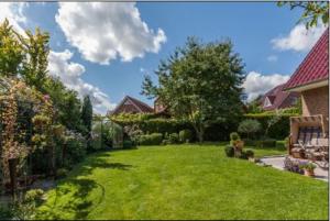 a yard with green grass and a house at Neptun17 in Scharbeutz