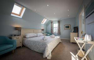um quarto com uma cama grande e uma cadeira azul em Canowindra em Portree