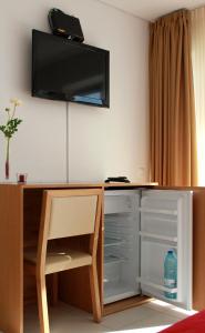 a room with a desk with a tv on the wall at Casa Praia Mar in Salema