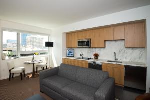 a living room with a couch and a kitchen at The Study at University City, Study Hotels in Philadelphia