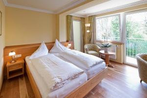 ein Schlafzimmer mit einem großen Bett mit weißer Bettwäsche in der Unterkunft Seevilla Altaussee in Altaussee + 23 Fotos