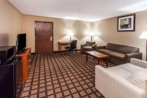 a hotel room with a couch and a tv and a living room at Baymont by Wyndham New Buffalo in New Buffalo