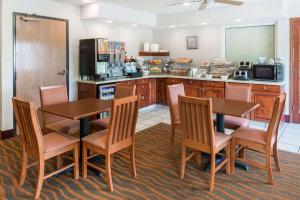 a kitchen with a table and chairs and a counter at Baymont by Wyndham Rolla in Rolla