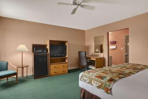 a hotel room with a bed and a flat screen tv at Baymont by Wyndham Sullivan in Sullivan
