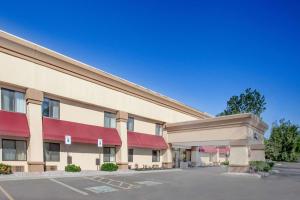 a large building with red awnings in a parking lot at Baymont by Wyndham Jackson in Jackson