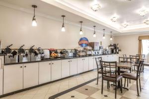 uma cozinha com mesa e cadeiras num quarto em Baymont by Wyndham Galveston em Galveston