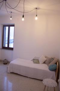 a white bedroom with a bed and a chair at Casa Sofì in Tolentino