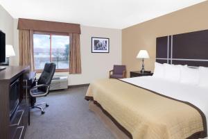 a hotel room with a large bed and a window at Baymont by Wyndham Green Bay in Green Bay